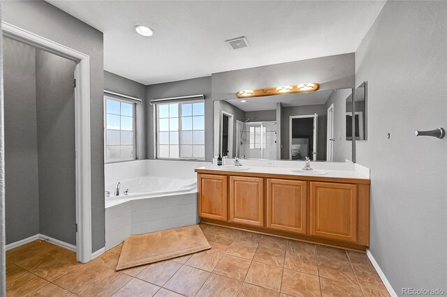 full bath with a bath, double vanity, and baseboards