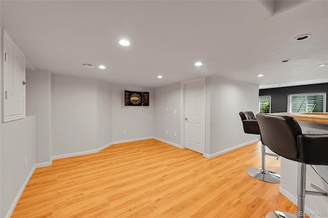 exercise area featuring light wood-style floors, recessed lighting, and baseboards