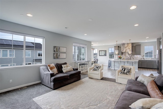 living room featuring baseboards, a wealth of natural light, and recessed lighting