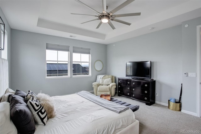 carpeted bedroom with baseboards, ceiling fan, visible vents, and a raised ceiling