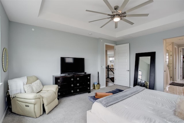 bedroom with carpet flooring, a ceiling fan, a raised ceiling, baseboards, and visible vents