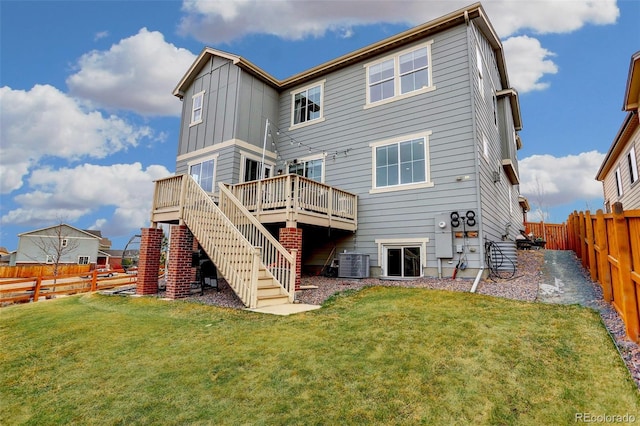 back of property with a wooden deck, stairs, a fenced backyard, central AC, and a lawn