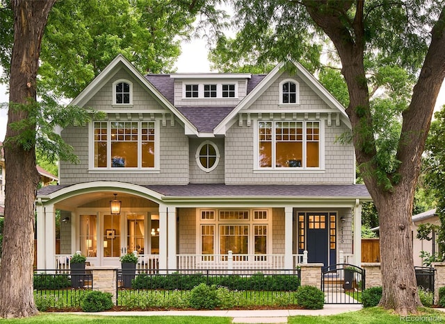 2130 S Milwaukee St, Denver, CO 80210 - view of front of property featuring a porch, fence, and a shingled roof