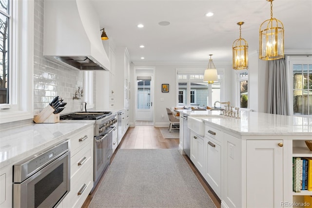2130 S Milwaukee St, Denver, CO 80210 - kitchen with premium range hood, light wood-type flooring, backsplash, appliances with stainless steel finishes, and crown molding