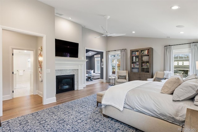 2130 S Milwaukee St, Denver, CO 80210 - bedroom featuring a glass covered fireplace, lofted ceiling, multiple windows, and wood finished floors