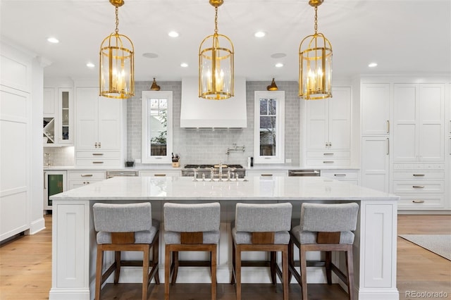 2130 S Milwaukee St, Denver, CO 80210 - kitchen featuring wine cooler, white cabinetry, light wood-type flooring, and tasteful backsplash