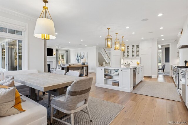 2130 S Milwaukee St, Denver, CO 80210 - dining space with light wood-style flooring, recessed lighting, a fireplace, crown molding, and a chandelier