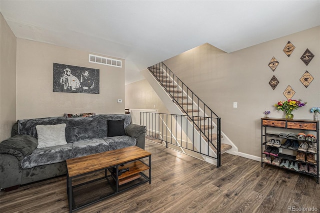 living area with stairway, wood finished floors, visible vents, and baseboards