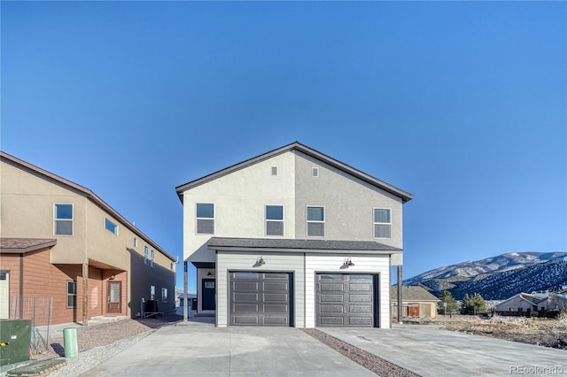 rear view of property featuring a mountain view and a garage