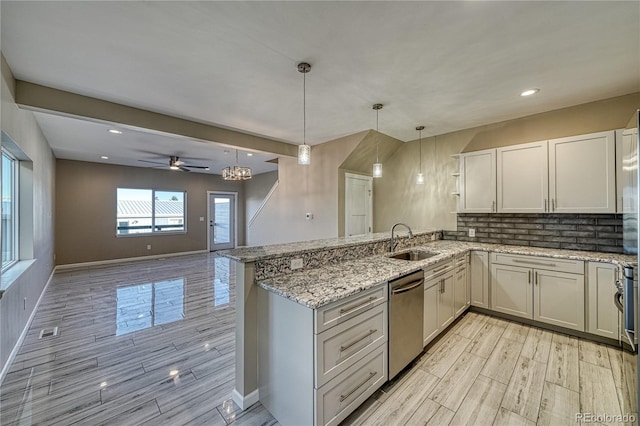 kitchen with dishwasher, sink, light hardwood / wood-style flooring, kitchen peninsula, and decorative light fixtures