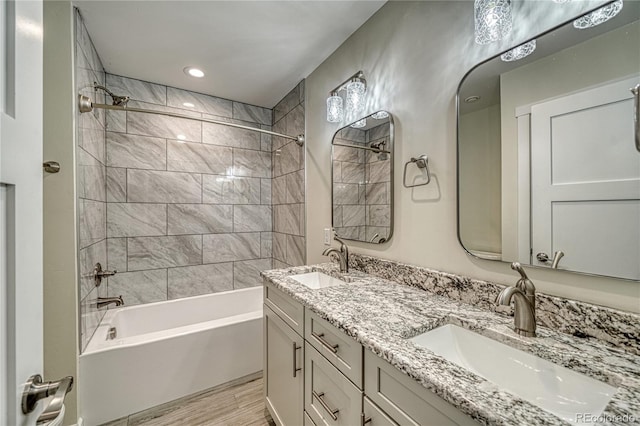 bathroom featuring vanity, wood-type flooring, and tiled shower / bath