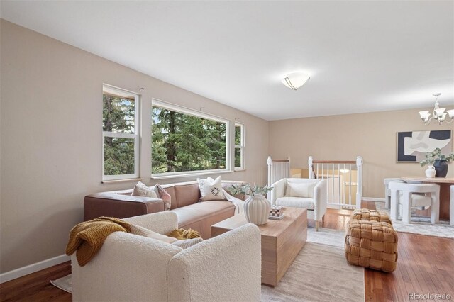30321 Chestnut Dr, Evergreen, CO 80439 - living room featuring light wood-style flooring, a chandelier, and baseboards