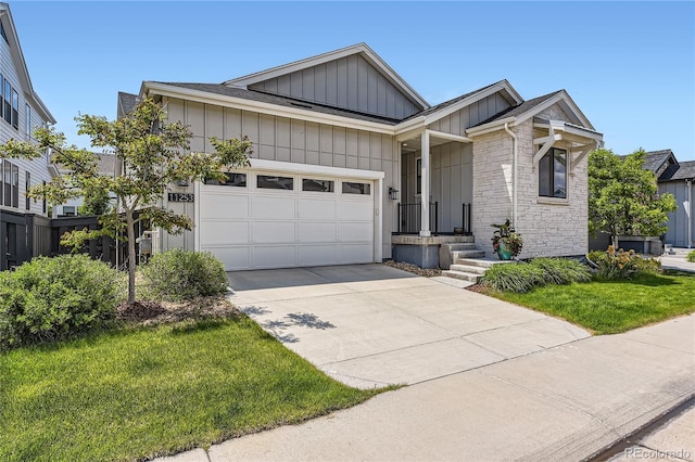 11253 Moondance Trl, Littleton, CO 80125 - view of front of home featuring board and batten siding, an attached garage, driveway, stone siding, and a front lawn