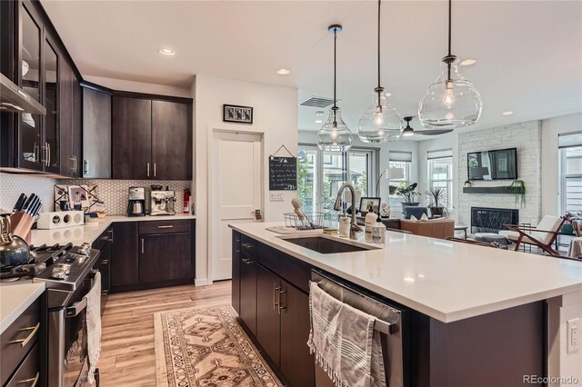 11253 Moondance Trl, Littleton, CO 80125 - kitchen with appliances with stainless steel finishes, a sink, light countertops, light wood finished floors, and backsplash