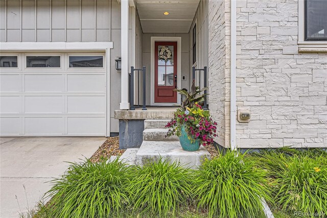 11253 Moondance Trl, Littleton, CO 80125 - doorway to property with an attached garage, stone siding, and board and batten siding