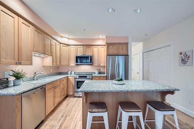 753 Pearl St, Boulder, CO 80302 - kitchen with stainless steel appliances, a sink, a breakfast bar area, and light wood-style floors
