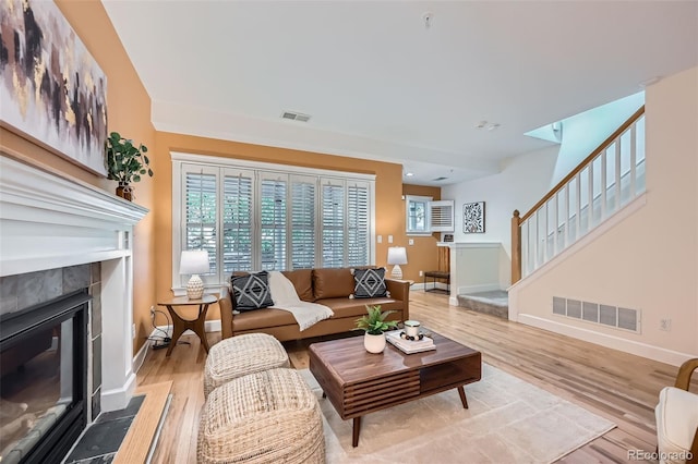 753 Pearl St, Boulder, CO 80302 - living room with baseboards, a tiled fireplace, light wood-style flooring, and stairway