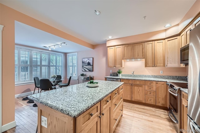 753 Pearl St, Boulder, CO 80302 - kitchen with appliances with stainless steel finishes, a sink, light wood-style flooring, a kitchen island, and light stone counters