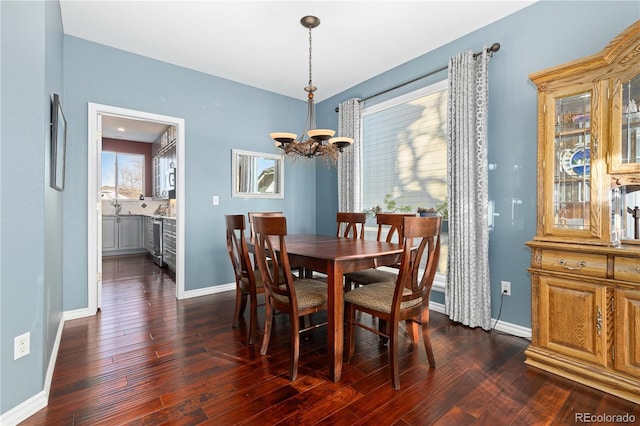 dining space with an inviting chandelier and dark hardwood / wood-style flooring