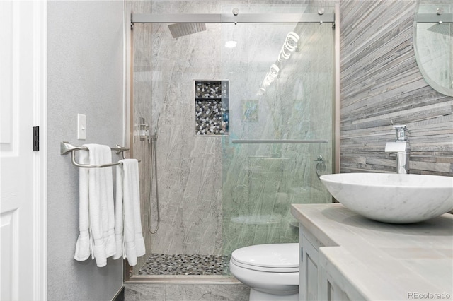 bathroom featuring vanity, an enclosed shower, and toilet