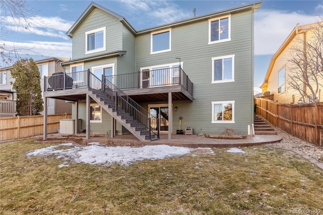 rear view of property with a deck and a lawn