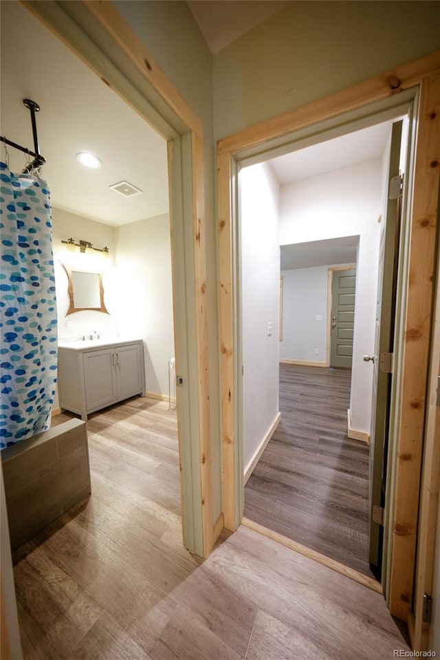 hallway featuring sink and light hardwood / wood-style floors