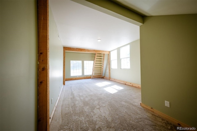 unfurnished room featuring light colored carpet and lofted ceiling