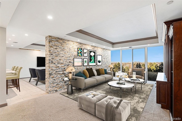 carpeted living room featuring a tray ceiling and ornamental molding