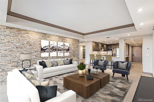 tiled living room featuring a tray ceiling and crown molding