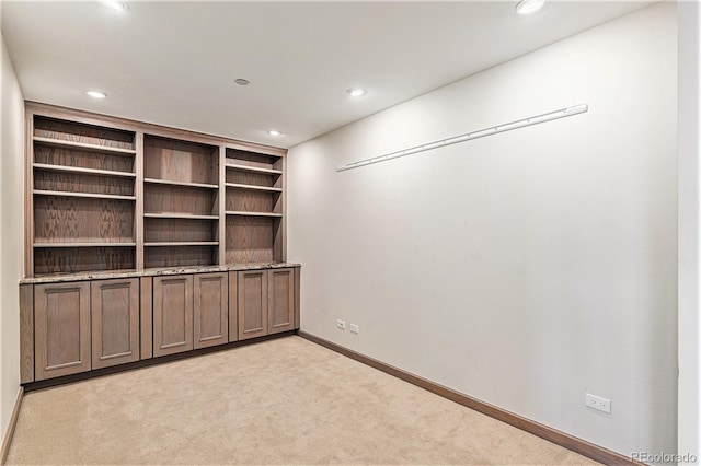 interior space featuring built in shelves and light carpet