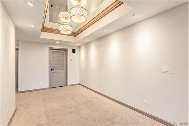 carpeted spare room featuring a raised ceiling