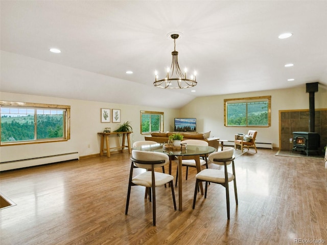 6066 Crawford Gulch Rd, Golden, CO 80403 - dining room featuring a baseboard heating unit, a wood stove, wood finished floors, vaulted ceiling, and a chandelier