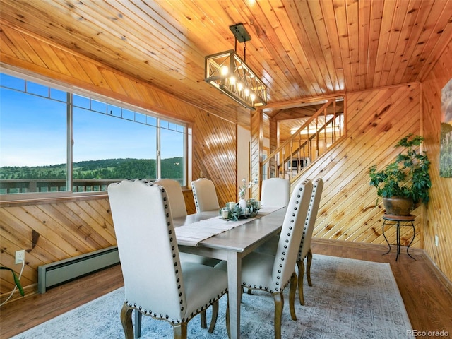 6066 Crawford Gulch Rd, Golden, CO 80403 - dining space with a baseboard radiator, wood finished floors, a chandelier, wood walls, and wooden ceiling