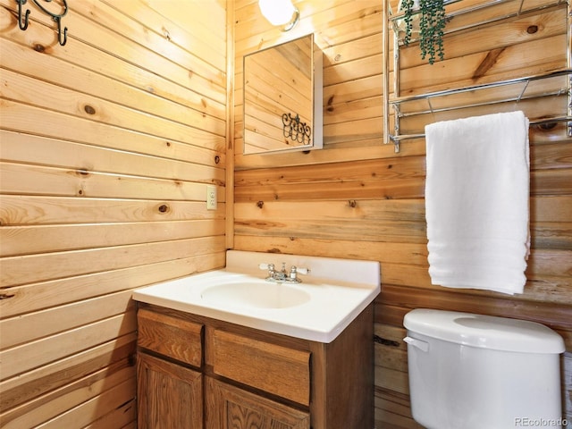 6066 Crawford Gulch Rd, Golden, CO 80403 - bathroom with vanity, wooden walls, and toilet
