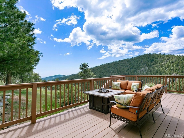 6066 Crawford Gulch Rd, Golden, CO 80403 - deck featuring a mountain view, an outdoor living space with a fire pit, and a view of trees