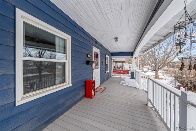 snow covered deck with a porch