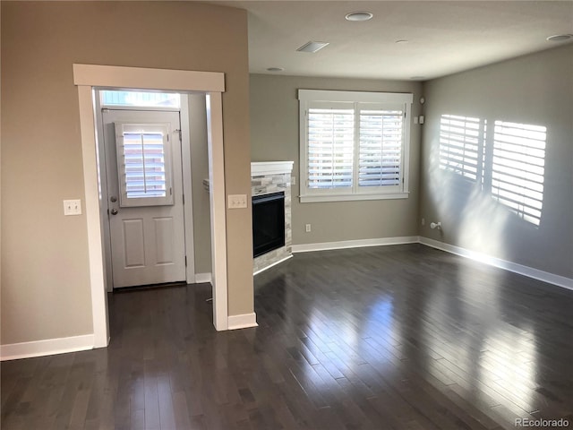 entrance foyer featuring a fireplace and dark wood-type flooring