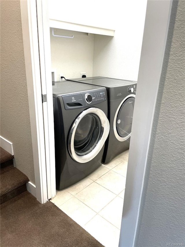 clothes washing area featuring separate washer and dryer and light tile patterned flooring