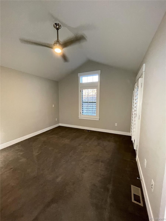 additional living space featuring dark carpet, ceiling fan, and lofted ceiling