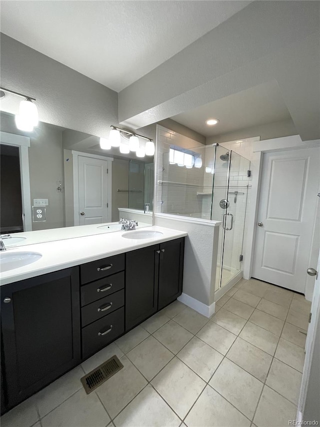 bathroom featuring a shower with door, vanity, and tile patterned flooring