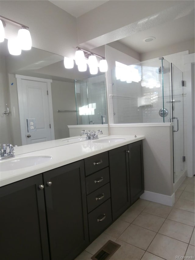 bathroom featuring tile patterned flooring, vanity, and a shower with shower door