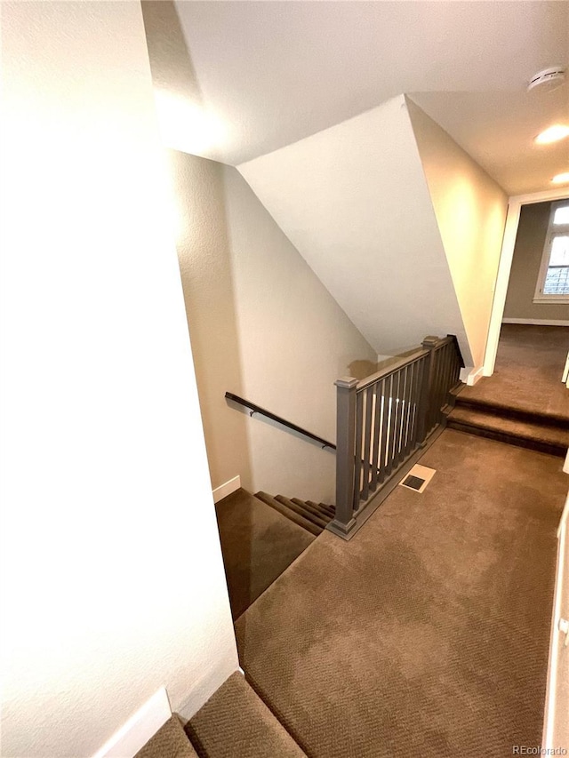 stairs with carpet floors and lofted ceiling