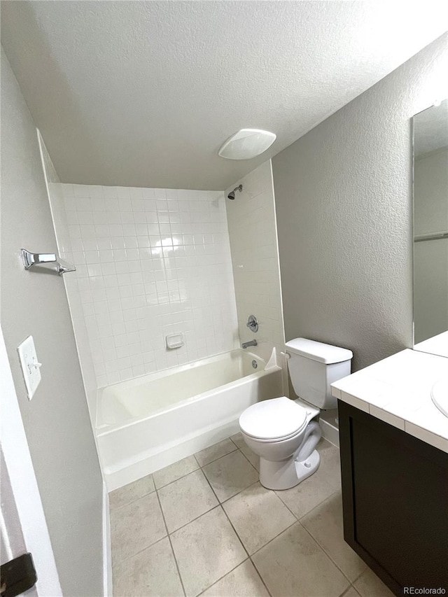 full bathroom with vanity, tile patterned flooring, tiled shower / bath combo, toilet, and a textured ceiling