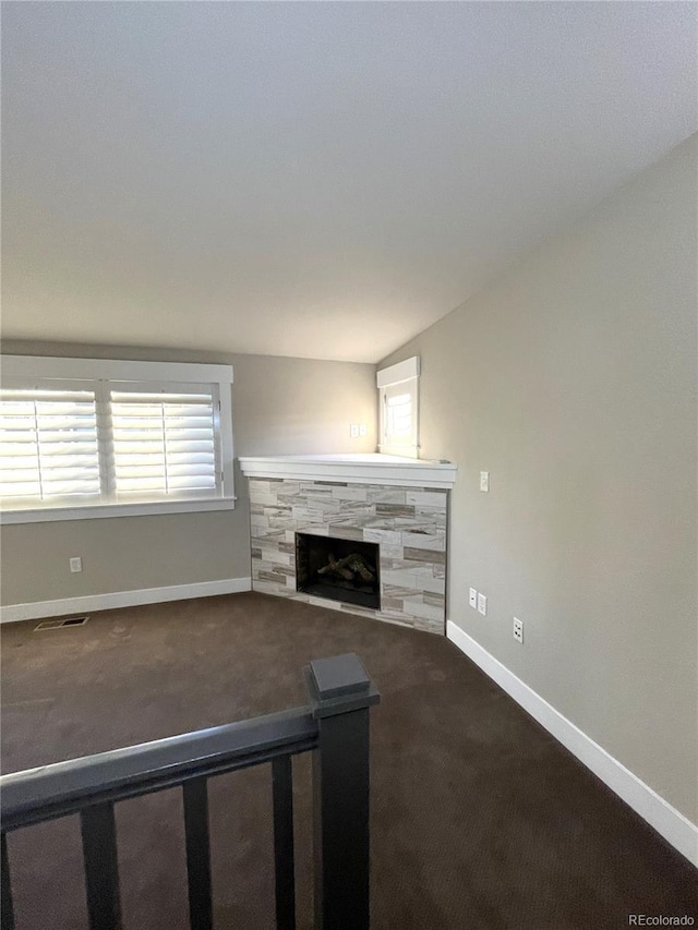 unfurnished living room featuring a fireplace, carpet floors, and vaulted ceiling