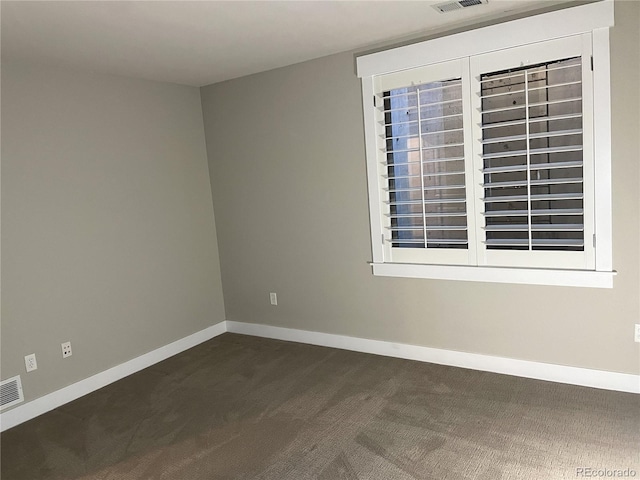 unfurnished room featuring dark colored carpet