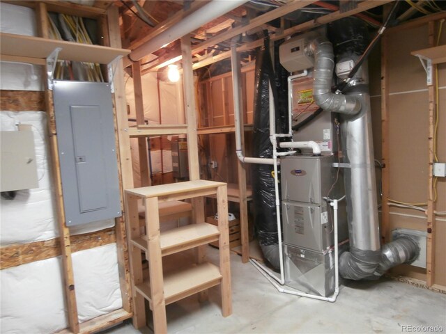 utility room featuring electric panel and heating unit