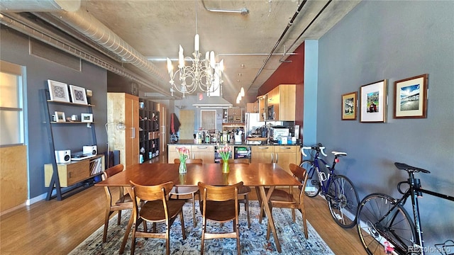 dining area with wood-type flooring and a notable chandelier