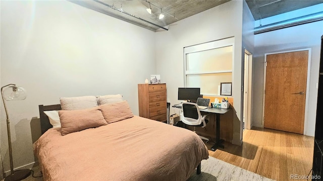 bedroom featuring rail lighting and light hardwood / wood-style floors