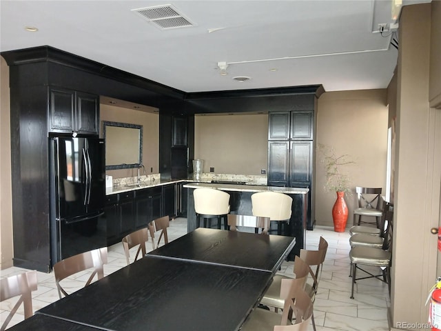 4570 E Yale Ave Unit 706, Denver, CO 80222 - kitchen with freestanding refrigerator, light countertops, dark cabinets, visible vents, and a kitchen island