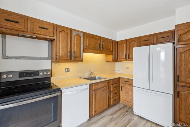 4570 E Yale Ave Unit 706, Denver, CO 80222 - kitchen featuring a sink, light wood-style floors, white appliances, brown cabinets, and light countertops